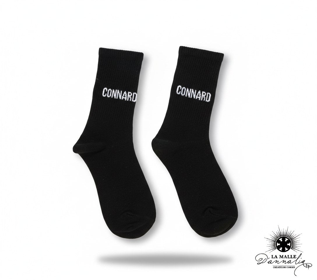 Chaussettes noires avec texte "CONNARD" brodé en blanc lamalledannalia