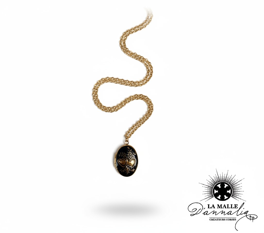 Collier doré avec un médaillon ovale noir orné de deux cœurs et motifs végétaux dorés. lamalledannalia