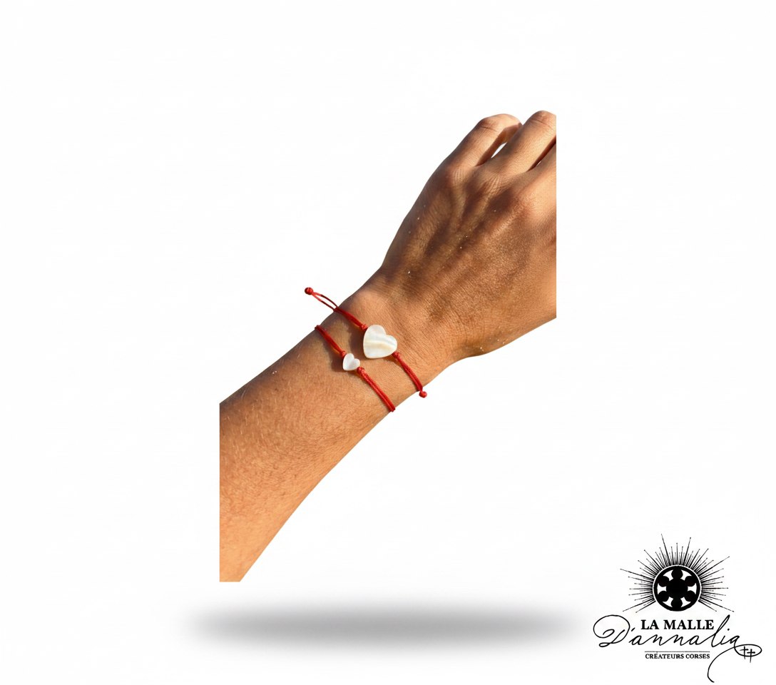 Deux bracelets fil rouge avec cœurs en nacre blanche portés sur un poignet lamalledannalia
